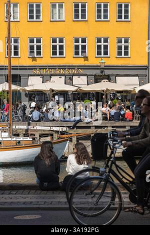 Dänemark Junge Menschen, Blick auf junge Dänen, die einen Frühlingstag im Nyhavn-Hafengebiet von Kopenhagen, Dänemark, genießen. Stockfoto