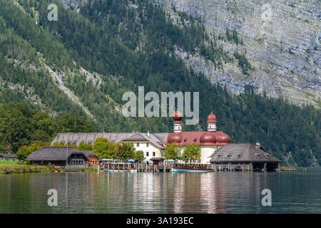 Wunderschöner Blick auf die Wallfahrtskirche St. Bartholomae am Ufer des Königssees mit alpen im Hintergrund im Nationalpark Berchstegaden, auf einem sonnigen Su Stockfoto