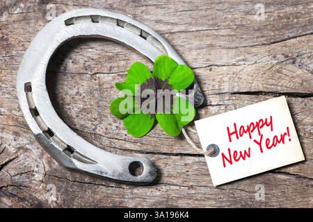 Hufeisen, Schamrock und Sektkork mit einem Anhänger auf altem Holz Stockfoto