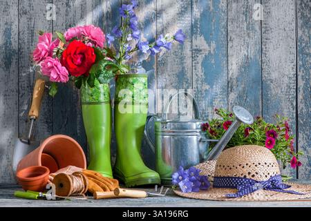Gartengeräte und Blumen auf der Terrasse im Garten Stockfoto