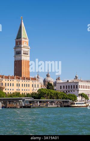 Venedig, Italien - 12. Oktober 2024: Der Markusplatz und die Kuppeln der Basilika di San Marco erheben sich über dem venezianischen Ufer unter einem klaren blauen Himmel. Stockfoto
