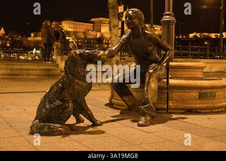 Budapest, Ungarn - 26. Oktober 2021: Mädchen mit ihrem Hund Statue in der Nacht in Budapest, Ungarn. Stockfoto