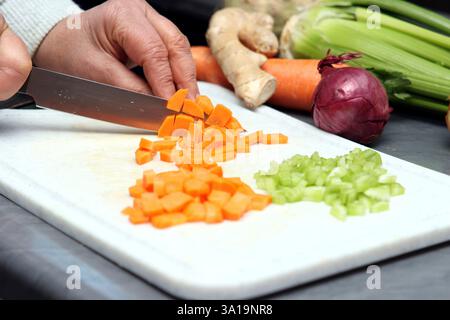 Frau schneidet Karotten in kleine Würfel Stockfoto