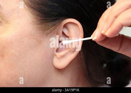 Ohrenpflege mit einem Wattestäbchen Stockfoto