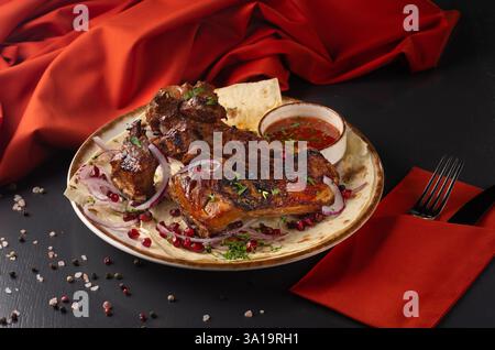 Gebratene Lammrippe, über Kohlen auf dunklem Hintergrund gegrillt. Menü für ein georgianisches Restaurant. Restaurantmenü. Stockfoto