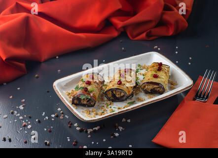 Traditionelle georgianische Gerichte: Auberginen Rolls kakliani mit Walnusspaste mit Granatapfelkernen und Petersilie. Menü für ein georgianisches Restaurant. Stockfoto