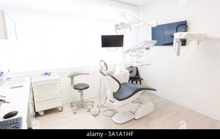 Leere Zahnklinik mit moderner Ausstattung, einschließlich eines Zahnarztstuhls, Monitors und anderer Werkzeuge, die für Patienten bereit sind Stockfoto