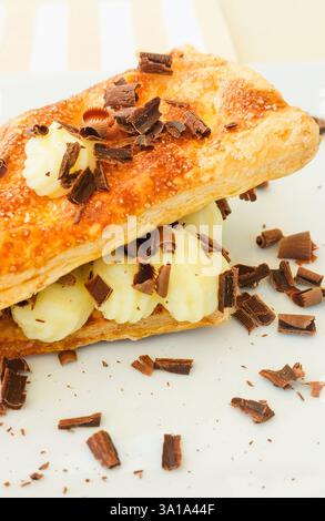 Nahaufnahme eines köstlichen Millefoglie-Desserts mit üppiger Gebäckcreme und zart bestreuter Schokolade Stockfoto