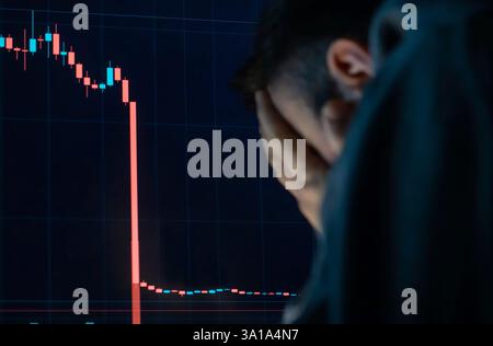 Frustrierter, depressiver Mann, der Kopf in den Händen hält, schockiert, als der globale Aktienmarkt sinkt. Stockfoto