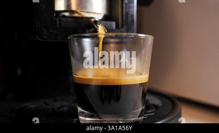 Espresso-Kaffee in einer Glastasse. Kaffeemaschine. Stockfoto