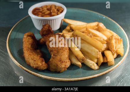 Kindermahlzeit mit Chicken Nuggets, Pommes Frites und gebackenen Bohnen. Stockfoto