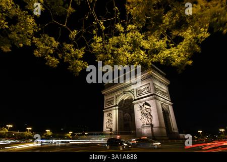 Nächtlicher Blick auf den Triumphbogen mit leichten Spuren des Pariser Verkehrs - Paris, Frankreich Stockfoto