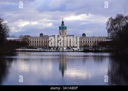 Die wunderschöne Barockfassade des Schlosses Charlottenburg in Berlin spiegelt sich an einem verschneiten Wintertag auf dem See im Schlosspark Stockfoto