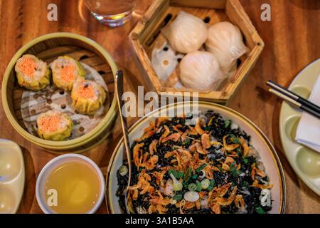 Gedämpftes Dim Sum-Sortiment, einschließlich Shu mai, Har Gow und schwarzem Reis mit getrockneten Garnelen in einem authentischen chinesischen Restaurant in San Francisco Stockfoto
