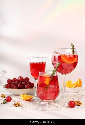 Gläser Traubencocktail, Rotwein und Saft mit Trauben, Eis- und Zitrusscheiben auf sonnigem Hintergrund, Bar- und Sommerpartykonzept, Restaurant und Café Stockfoto