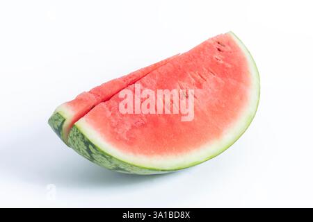 Eine Nahaufnahme einer lebendigen und frischen Wassermelonenscheibe mit leuchtendem rosafarbenem Fleisch und grüner Haut. Stockfoto
