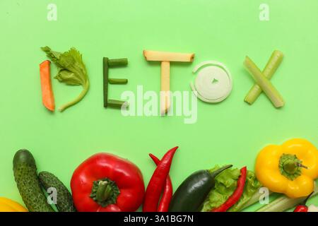 Komposition mit Wort DETOX und verschiedenen Gemüsesorten auf grünem Hintergrund Stockfoto
