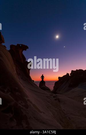 Mond, Venus und Saturn in der Abenddämmerung, gesehen von einem felsigen Ufer im Persischen Golf im südlichen Iran. Stockfoto