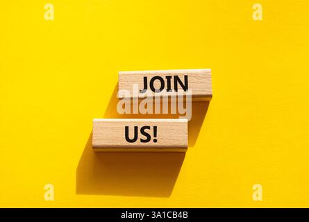 Schließen Sie sich uns an. Concept Word Kommen Sie uns auf Holzblöcken. Schöner gelber Hintergrund. Business und Join US-Konzept. Kopierbereich Stockfoto
