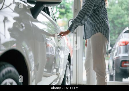 Öffnen der Tür. Nahaufnahme einer Frau mit Elektroauto. Stockfoto