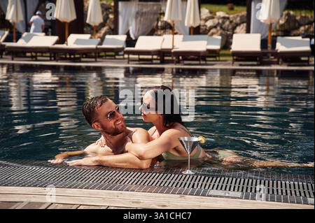 Sich gegenseitig umarmen. Mann mit Frau ist zusammen im Pool. Stockfoto