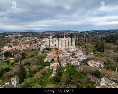 Aus der Vogelperspektive sehen Sie ein malerisches Dorf mit einem Kirchturm, eingebettet in üppiges Grün und charmante Häuser. Stockfoto