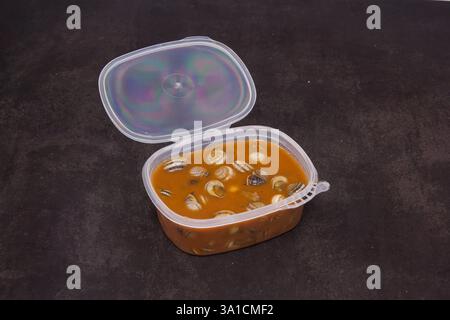 Ein Behälter mit Lebensmitteln mit Deckel oben. Der Deckel ist geöffnet und das Futter ist eine Mischung aus verschiedenfarbigen Lebensmitteln Stockfoto