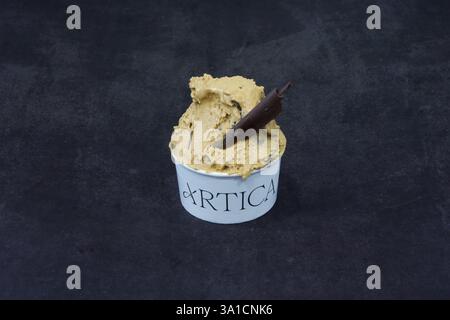 Eine Schaufel Eis mit einem Schokoladenstab darin. Das Eis ist in einer weißen Schüssel, auf der das Wort Artica steht Stockfoto