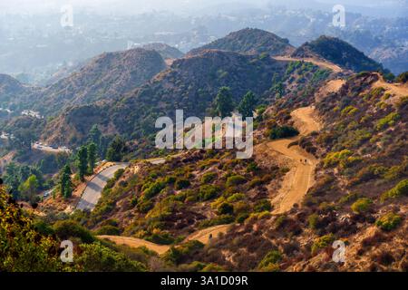 Wunderschöner Blick aus der Vogelperspektive auf gewundene Wanderwege und Hügel im Griffith Park, Los Angeles, mit üppiger Vegetation und Pfaden für Outdoor-Aktivitäten. Stockfoto