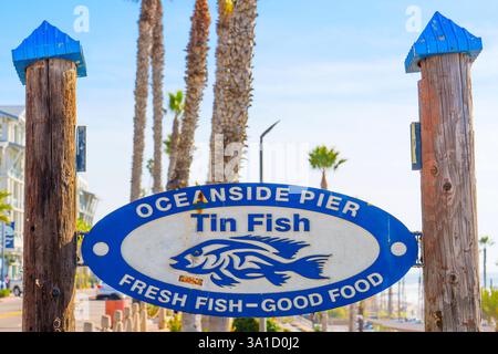 Oceanside, Kalifornien - 27. Dezember 2024: Schild für Tin Fish am Oceanside Pier mit frischem Fisch und Palmen. Stockfoto