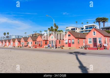 Oceanside, Kalifornien - 27. Dezember 2024: Farbenfrohe Strandhütten entlang der Sandküste mit Palmen. Stockfoto