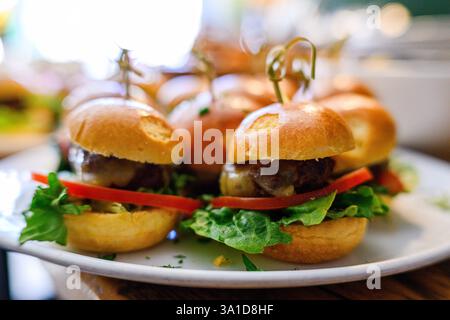 Köstliche Mini-Burger auf Teller, perfekt für Vorspeisen oder Partygerichte Stockfoto