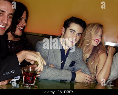 Fröhliche Leute, Freunde und Nacht mit Getränken für Party, Feier oder Ausflug in der Bar. Gruppe, Lächeln und lachen zusammen am späten Abend oder Stockfoto