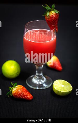 Glas Erdbeersaft mit Zitrone auf dunklem Hintergrund. Stockfoto