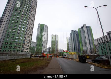 Weißrussland, Minsk - 26, 12, 2024: Eine lange Reihe von zahlreichen hohen Gebäuden, die sich über der Stadt erheben, mit einem auffälligen gelben Schild, das das Let kühn zeigt Stockfoto