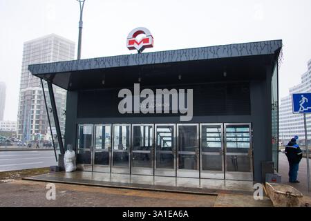 Weißrussland, Minsk - 26, 12, 2024: Ein Mann steht außerhalb eines Gebäudes, das das Wort U-Bahn auf seiner Außenseite deutlich zeigt, was auf sein Busin hindeutet Stockfoto