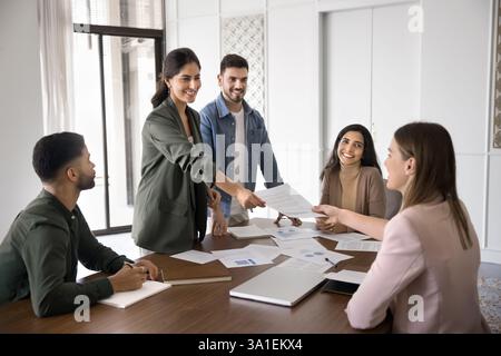 Weibliche Führungskraft übergibt Dokumente an Kunden oder Kollegen Stockfoto