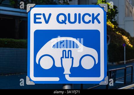 Schild mit der Aufschrift „EV Quick“ an einer EV-Ladestation (Elektrofahrzeug). Stockfoto
