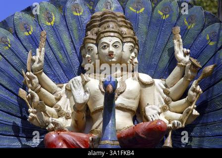 Farbenfroh bemalter Lord Kartikeya sitzt auf seinem Fahrzeugpfau an der Fassade des Shree Durga Parmeshwari Tempels in Kateel, Dakshina Kannada District, Ka Stockfoto