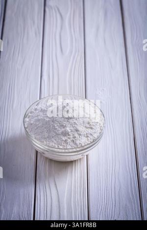Natürliches Mehl in Glasschale auf weiß bemalten alten Holzbrettern Essen und Trinken Konzept Stockfoto