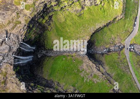 Atemberaubender Blick aus der Vogelperspektive auf den Wasserfall und die grüne Landschaft auf den Färöern Stockfoto