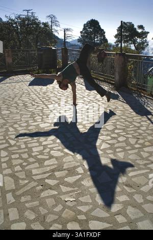 Französischer akrobat mit einem Arm Handstand, um ein Spiel von Schatten, Mussoorie, Dehra Dun, Uttaranchal Uttarakhand zu schaffen Stockfoto