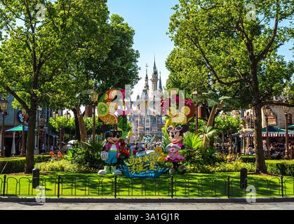 Shanghai, China - 12. August 2020: Mickey und Minnie Maus treffen sich vor dem Shanghai Disneyland Castle inmitten üppiger Grünflächen und lebendiger Dekoration Stockfoto