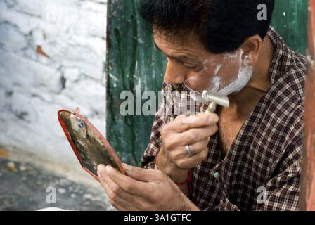Ein Mann rasiert sich auf der Straße in Jammu, Indien, Asien Stockfoto