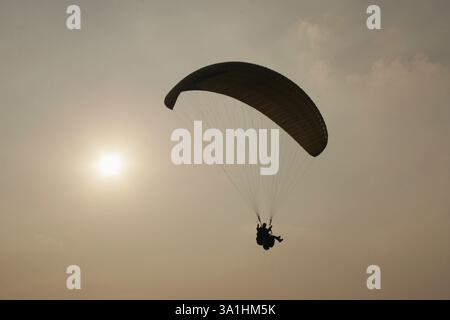 Gleitschirmflieger, die sich gegen die untergehende Sonne amüsieren, Panchgani, Maharashtra, Indien, Asien Stockfoto