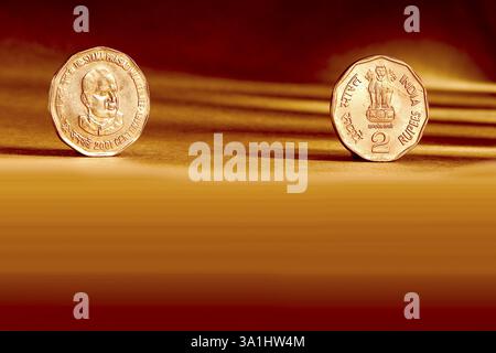 Doppelpaar indische Währung zwei Rupien Münzvorderseite und Rückseite geprägte Dr. Syama Prasad Mukherjee 2001 auf orangem Hintergrund Stockfoto