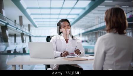 Unglücklicher Arzt sitzt in einem Disziplinartreffen mit schwarzem Hintergrund. Mögliche Berufe: Arzt, Krankenschwester, Zahnarzt, Polizist, Therapeut. Stockfoto