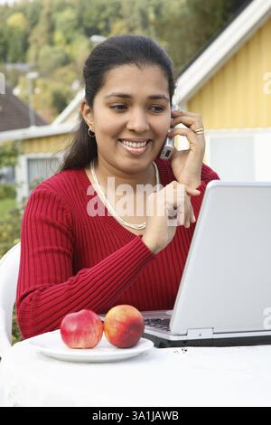 Junge Dame Blick auf Laptop mit dem sprechen auf mobile Herr #468 Stockfoto