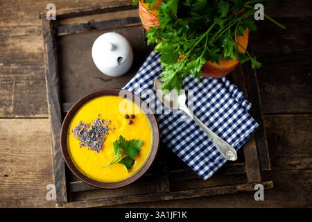 Schüssel Kürbissuppe mit Lavendelgarnitur Stockfoto