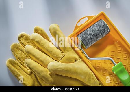 Leder-Sicherheitshandschuhe Malerwalze auf weißer Oberfläche Stockfoto